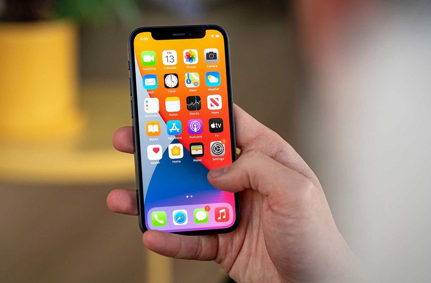 Person holding smartphone displaying app icons.