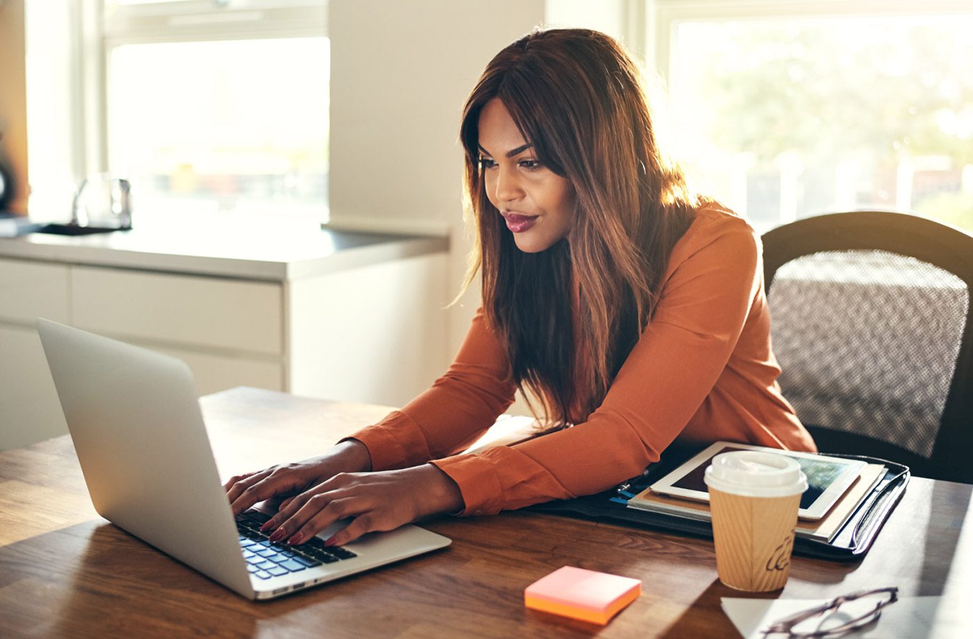 Woman working on a laptop at desk.