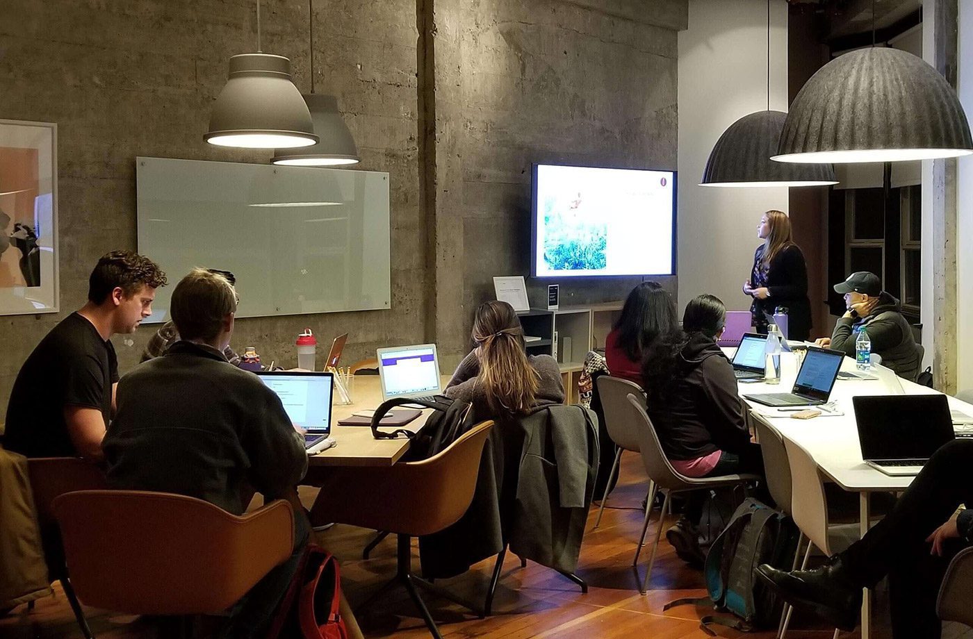 People in a meeting with presentation screen.