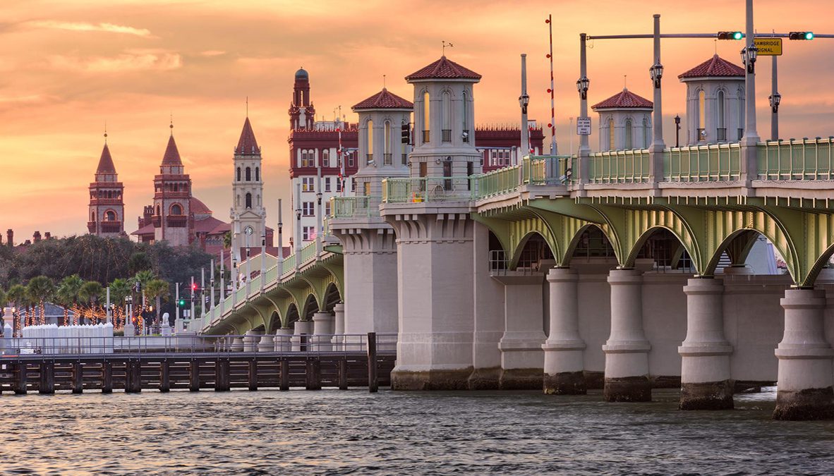 Historic bridge at sunset over calm water.
