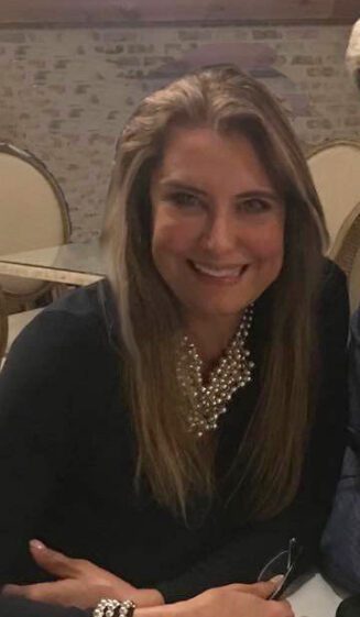 Smiling woman seated indoors at table.